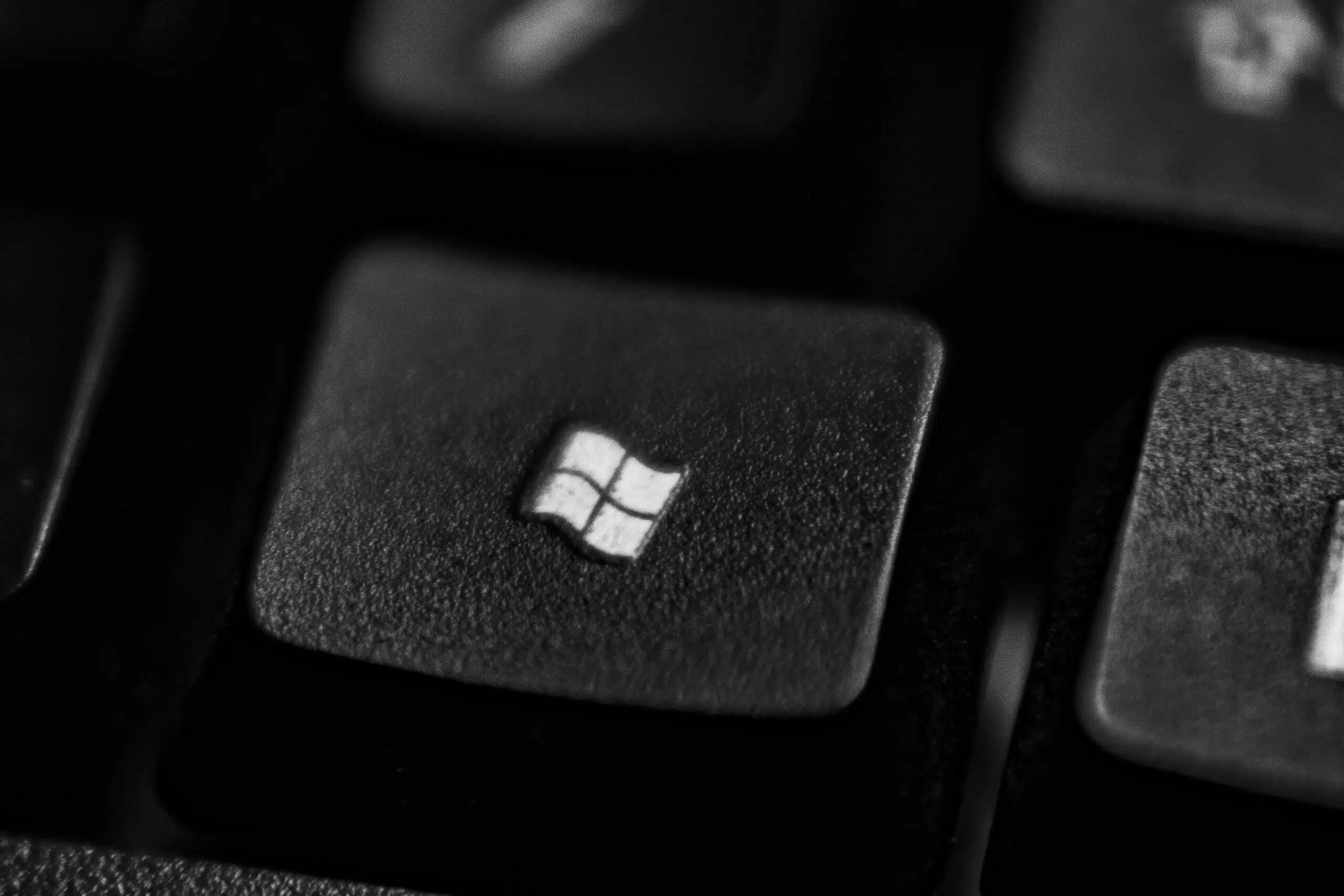 High-quality close-up of a Windows logo key on a black plastic keyboard.